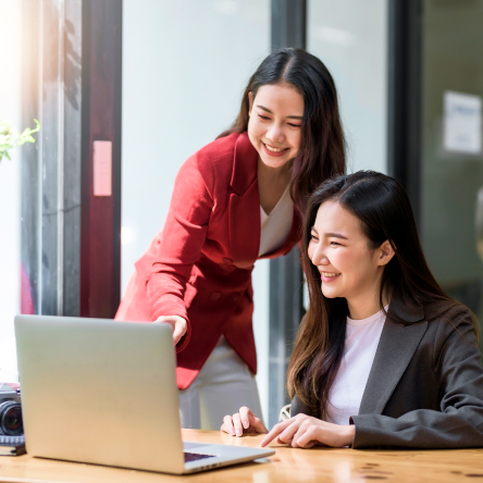 Two smiling businesswomen working together on a laptop